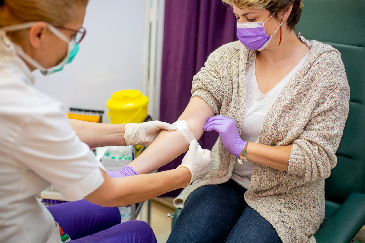 Applying adhesive bandage after taking sample for blood test — Stanford