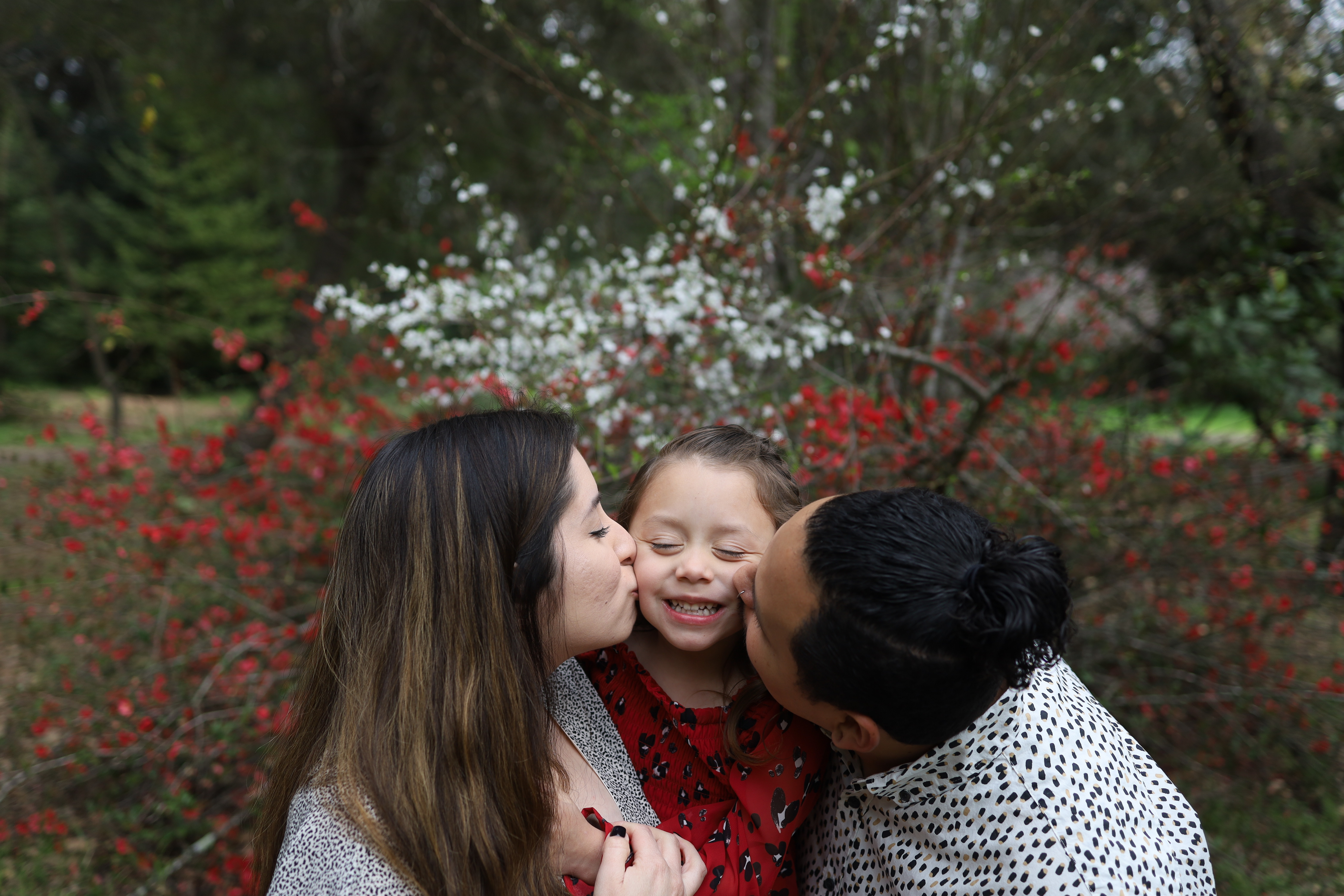 Penny being kissed on the cheek by her parents