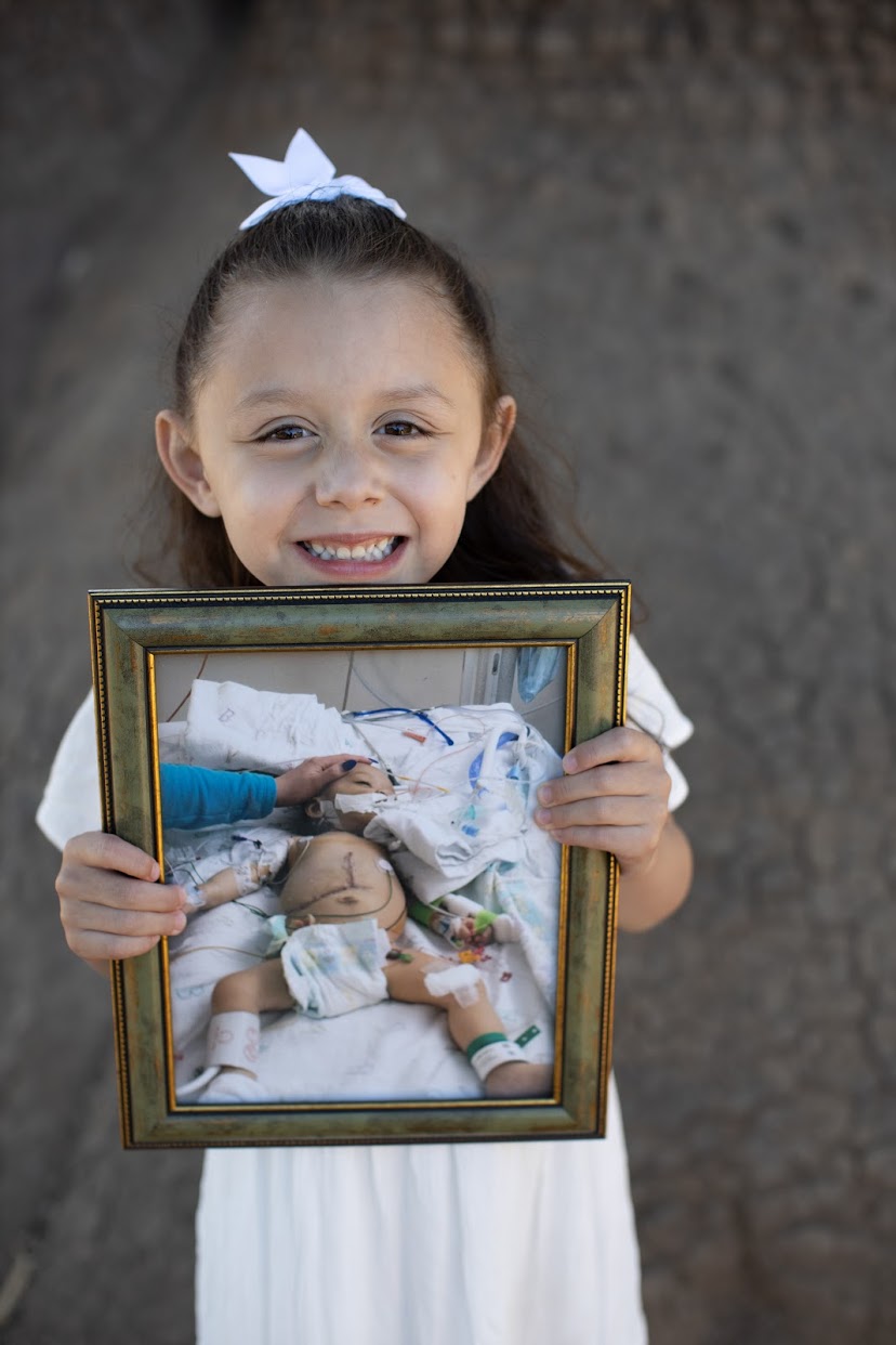 penny with photo of herself in the hospital as a baby