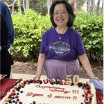 wendy leong in front of cake saying 50 years of service